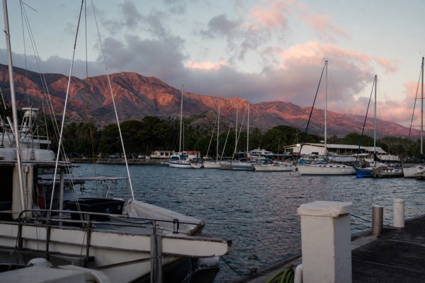 Boats in Maalaea Harbor at dusk with the West Maui mountains catching the last light