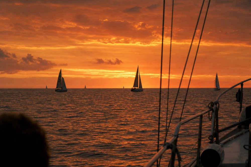 Deep orange afterglow filling the whole sky twenty minutes after the sun has gone with boat rigging in silhouette